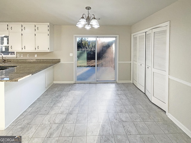 unfurnished dining area with a chandelier