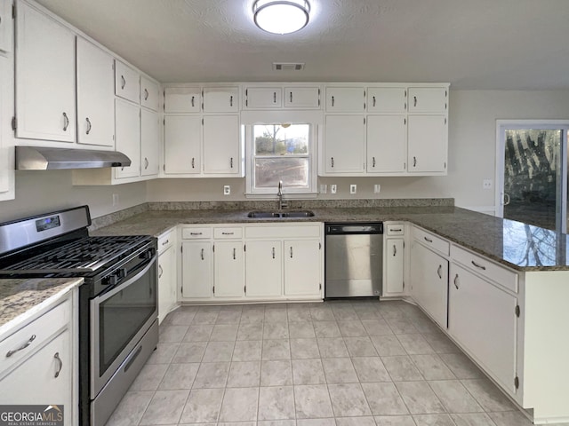 kitchen with appliances with stainless steel finishes, kitchen peninsula, sink, and white cabinets