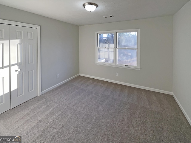 unfurnished bedroom featuring carpet flooring and a closet