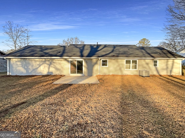 rear view of house featuring a lawn, central AC, and a patio area