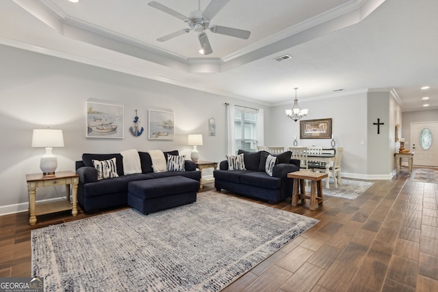 living room with crown molding, a tray ceiling, and dark wood-type flooring