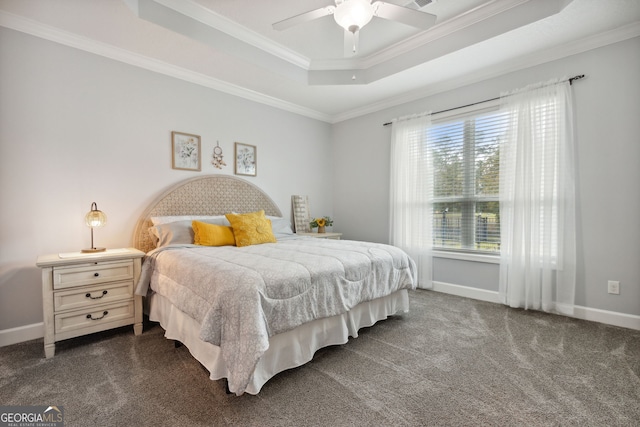 bedroom featuring a raised ceiling, dark colored carpet, ornamental molding, and ceiling fan