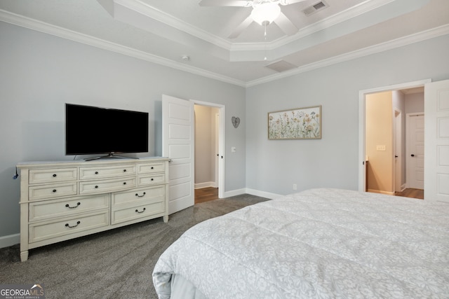 carpeted bedroom with a tray ceiling, ornamental molding, and ceiling fan