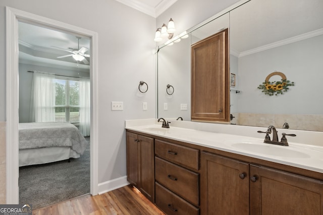 bathroom featuring hardwood / wood-style flooring, ornamental molding, vanity, and ceiling fan