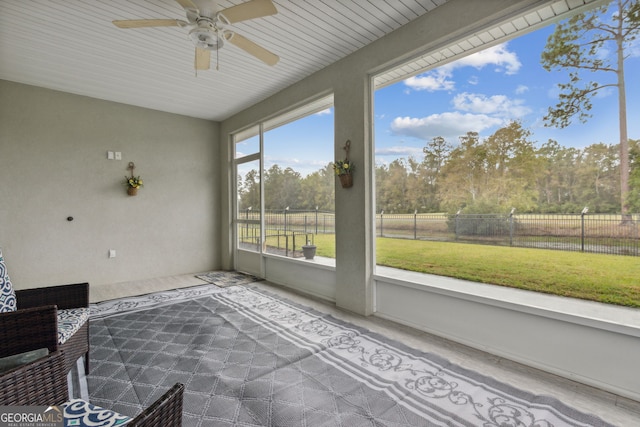 unfurnished sunroom featuring ceiling fan