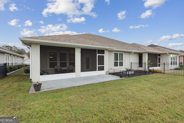 rear view of house with a lawn, a sunroom, and a patio area