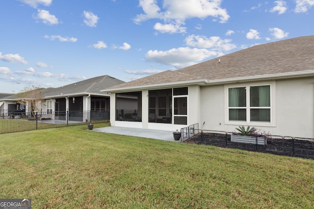 rear view of house featuring a yard, a patio area, and a sunroom