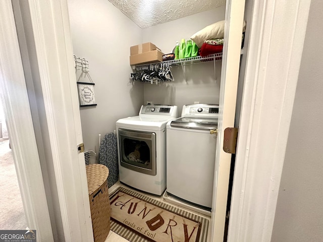 clothes washing area featuring washer and dryer and a textured ceiling