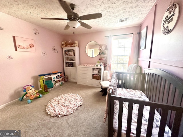 bedroom with ceiling fan, carpet floors, and a textured ceiling