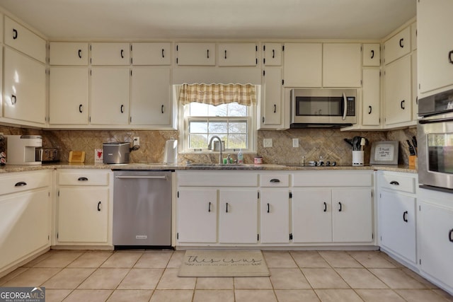 kitchen with stainless steel appliances, sink, white cabinets, and decorative backsplash