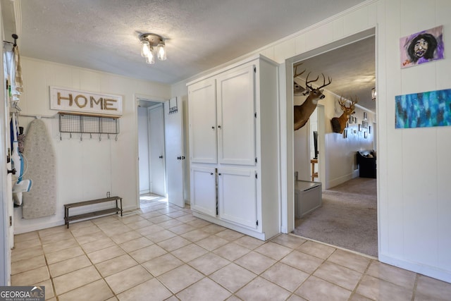 corridor with light carpet and a textured ceiling