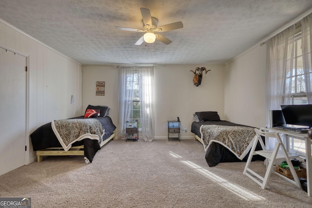 bedroom featuring crown molding, carpet floors, ceiling fan, and a textured ceiling