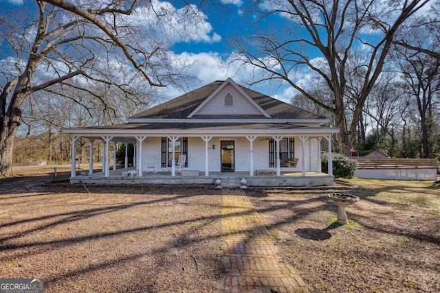 farmhouse inspired home featuring covered porch and a front yard