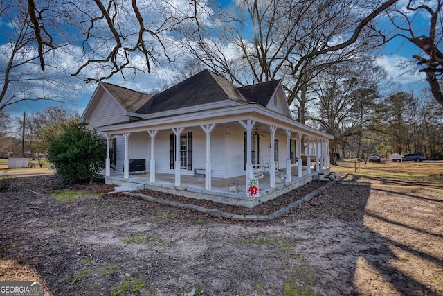 view of side of property featuring covered porch