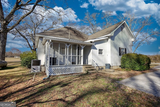 back of house featuring a porch, central AC, and a lawn