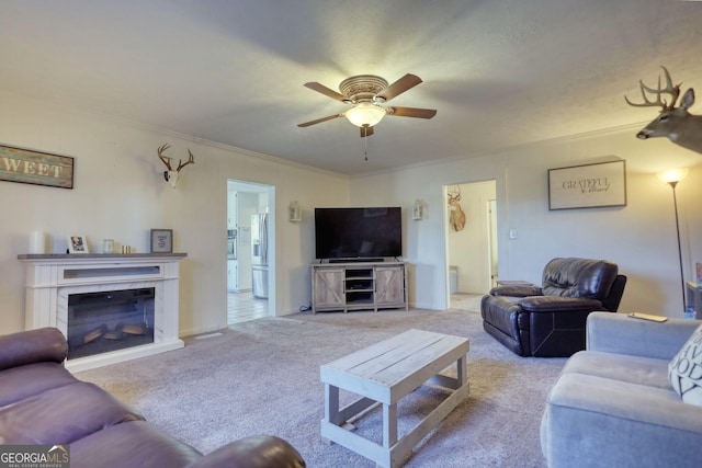 living room featuring ornamental molding, light carpet, and ceiling fan