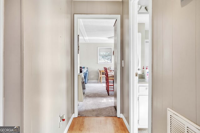 hall featuring wood walls and light wood-type flooring