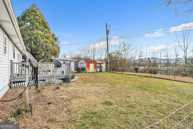 view of yard featuring a deck and a storage shed