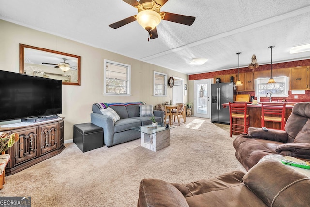 living room featuring light colored carpet, plenty of natural light, and a textured ceiling