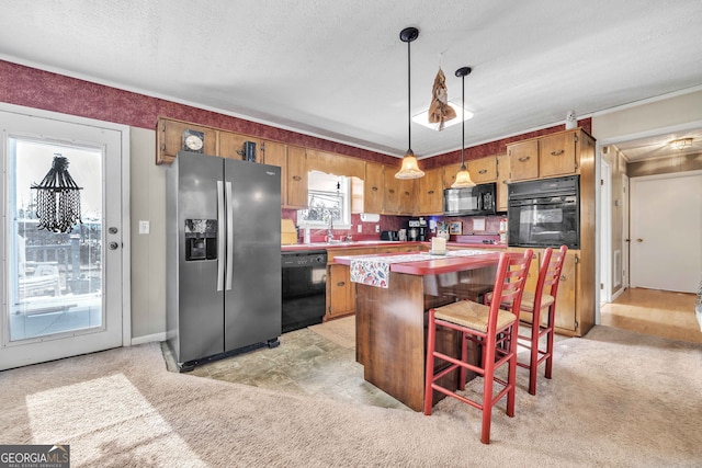 kitchen featuring a kitchen breakfast bar, decorative light fixtures, light carpet, and black appliances