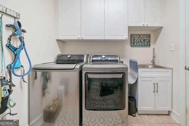 washroom featuring sink, washer and clothes dryer, cabinets, and light tile patterned flooring