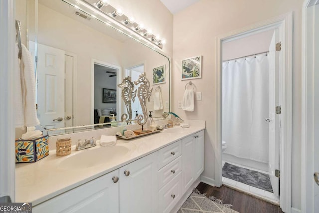 bathroom with a shower with curtain, vanity, hardwood / wood-style floors, and toilet