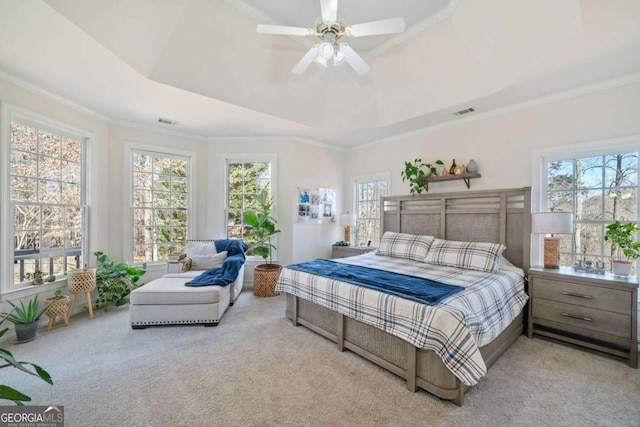 carpeted bedroom featuring crown molding, ceiling fan, and a tray ceiling