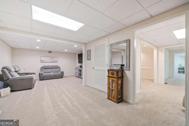 living room with a paneled ceiling and light carpet