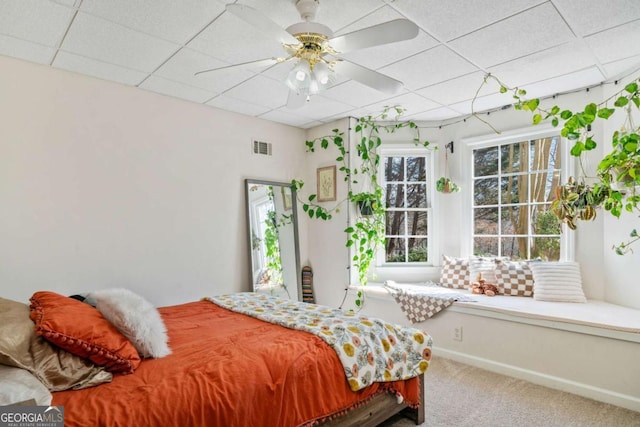 carpeted bedroom with a drop ceiling and ceiling fan