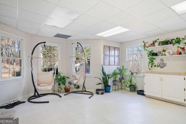 sunroom / solarium featuring a paneled ceiling and a wealth of natural light