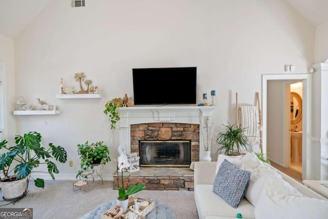 living room with lofted ceiling, a stone fireplace, and carpet