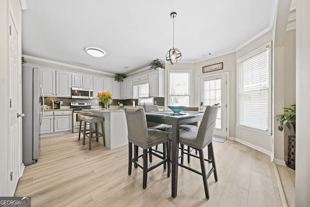 dining room featuring ornamental molding and light hardwood / wood-style flooring