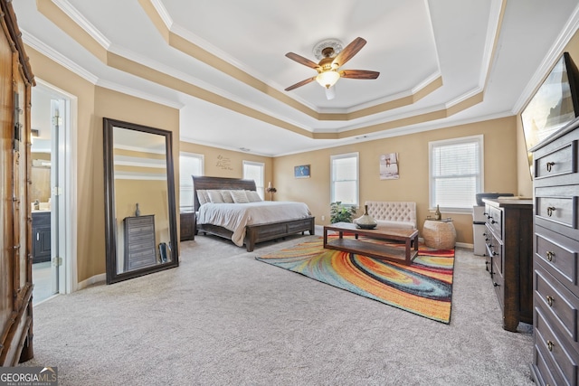 carpeted bedroom with crown molding, connected bathroom, and a raised ceiling