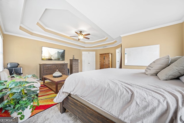 carpeted bedroom featuring ornamental molding, a raised ceiling, and ceiling fan