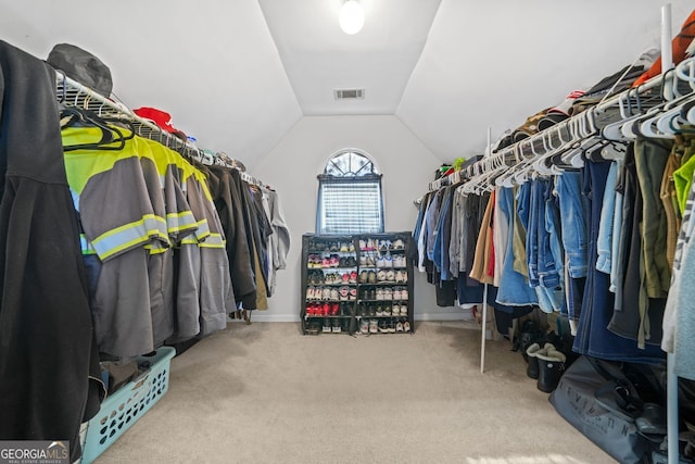 spacious closet with carpet floors and vaulted ceiling