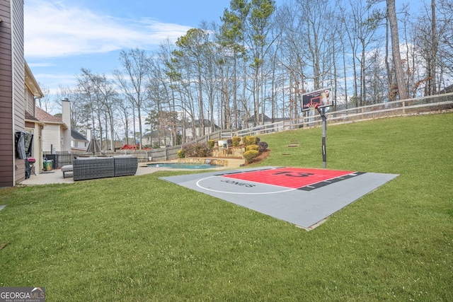 view of basketball court with a fenced in pool and a yard