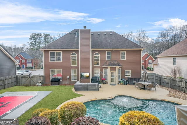 back of property with outdoor lounge area, a fenced in pool, a patio area, and a lawn