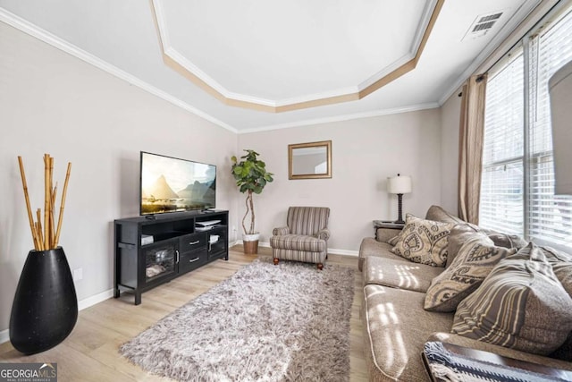 living room with crown molding, a raised ceiling, and light hardwood / wood-style flooring