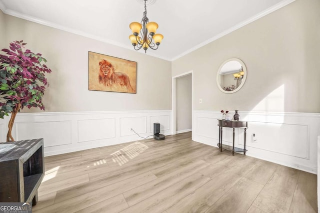 dining area with an inviting chandelier, ornamental molding, and light hardwood / wood-style flooring