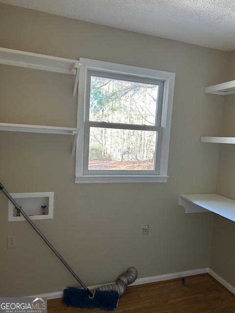 laundry room with washer hookup, hardwood / wood-style flooring, hookup for an electric dryer, and a textured ceiling