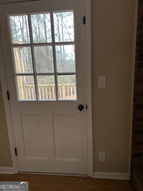 doorway to outside featuring dark wood-type flooring