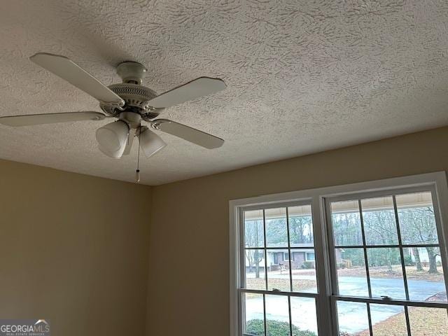 details with ceiling fan and a textured ceiling