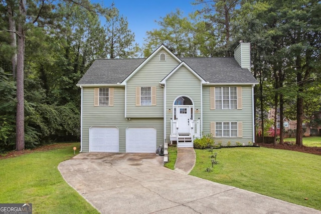 raised ranch featuring a garage and a front lawn