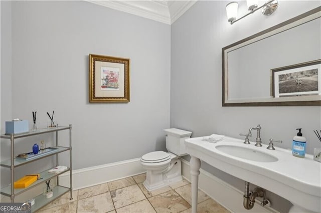 bathroom featuring sink, crown molding, and toilet