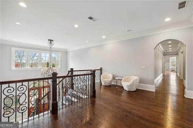 hall with ornamental molding, dark hardwood / wood-style flooring, and a notable chandelier