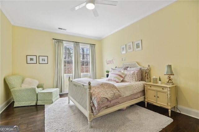 bedroom featuring ornamental molding, dark wood-type flooring, and ceiling fan