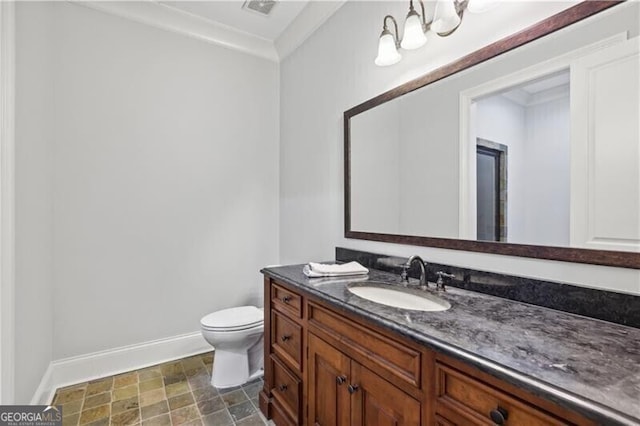 bathroom featuring vanity, crown molding, toilet, and an inviting chandelier