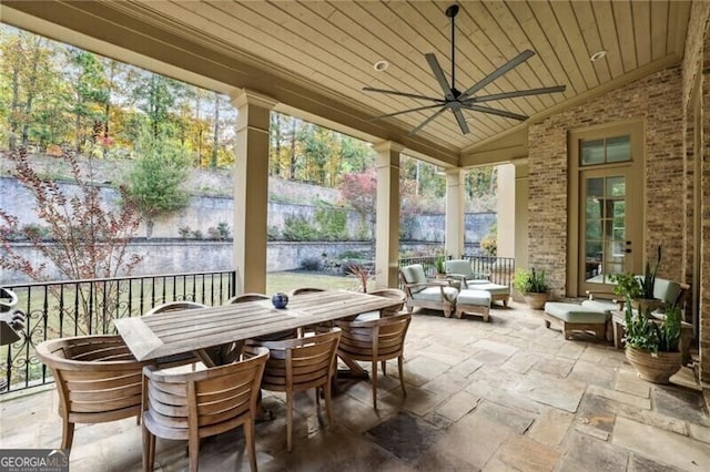 sunroom with vaulted ceiling, ceiling fan, and wood ceiling