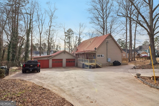 view of side of home featuring a garage and an outbuilding