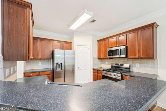 kitchen with crown molding, appliances with stainless steel finishes, kitchen peninsula, and tasteful backsplash